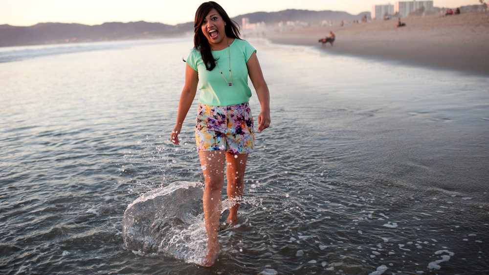 Kavita Happy on the beach kicking water